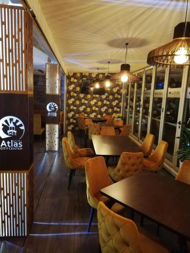 a restaurant with tables and chairs in a room at Atlas City Center Hotel in Prilep