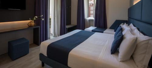 a hotel room with a bed with blue and white pillows at Hotel Benaco in Desenzano del Garda