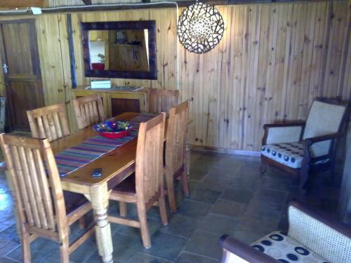 a dining room with a wooden table and chairs at Hadida Guesthouse in Swartruggens