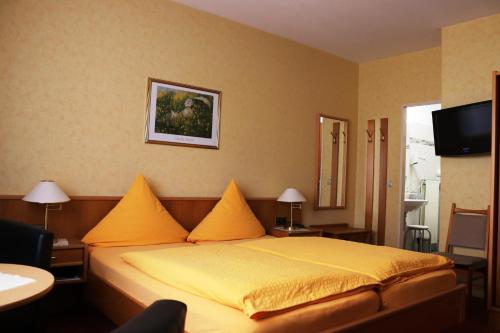 a bedroom with a large bed with yellow sheets at Weinstube Pension Moselblümchen in Zeltingen-Rachtig