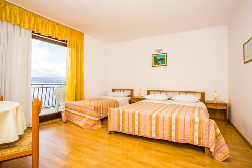 a hotel room with two beds and a balcony at Apartmani Pava in Omiš