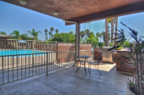 um pátio com uma piscina, uma mesa e cadeiras em Holiday Inn Express San Diego South - Chula Vista, an IHG Hotel em Chula Vista