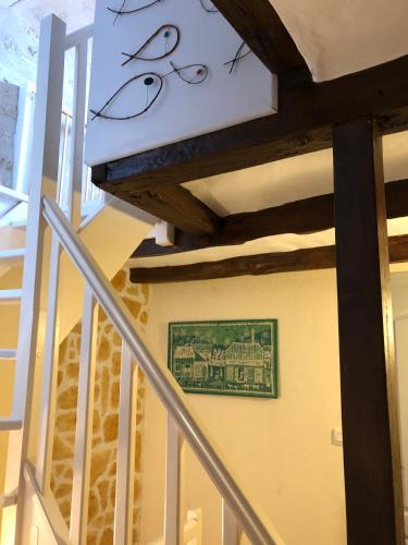 a painting of two eyes on a wall next to a staircase at Gîte des 2 frères in Saint-Pierre-de-Maillé