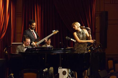 a woman standing in front of a microphone and a man playing a guitar at Hôtel de Paris Monte-Carlo in Monte Carlo