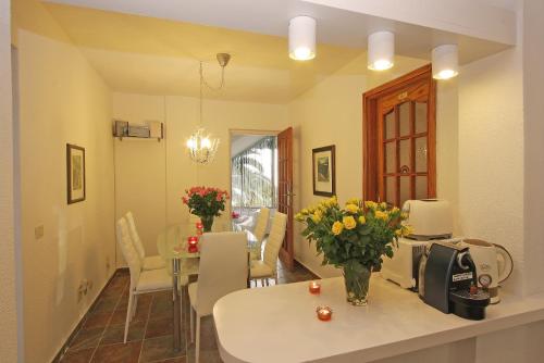 kuchnia i jadalnia z wazą kwiatów na stole w obiekcie Apartamento Bella Vista w mieście Tabaiba
