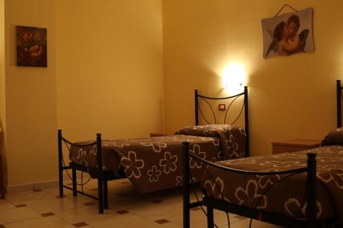a room with two beds and a light on the wall at Colle d'Elce in Deliceto