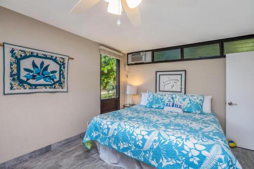 Un dormitorio con una cama azul y una ventana en Hale Moi 112A, King Bed, Kitchen, Washer Dryer, AC, Sunsets condo, en Princeville