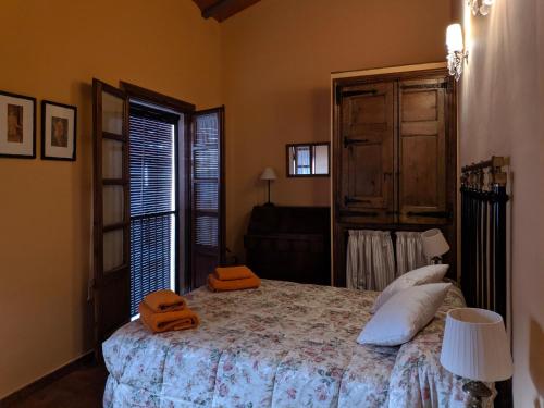 1 dormitorio con 1 cama con toallas de color naranja en L'Acadèmia de La Vilella Baixa 2, en La Vilella Baixa