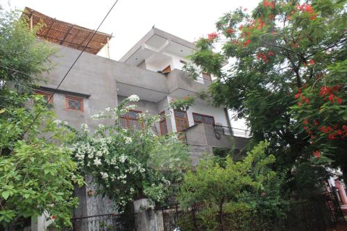 a white house with a fence and some trees at La Casa Art Stay in Udaipur