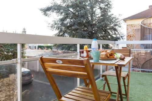 un balcon avec une table et une chaise dans l'établissement Appartement cozy: 10/15 min des Champs Élysée, à Sartrouville