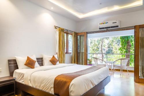 - une chambre avec un grand lit et un balcon dans l'établissement Amara Baga Villa 5BHK, à Baga