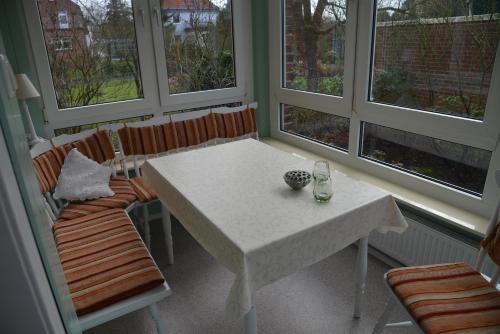 Biały stół i krzesła w pokoju z oknami w obiekcie Appartements AM ROSENGARTEN w mieście Celle
