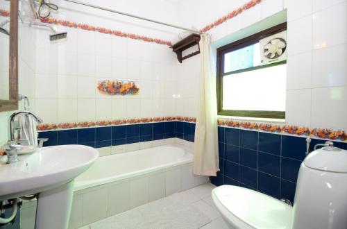 a bathroom with a sink and a tub and a toilet at Hotel Heritage Mandawa in Mandāwa