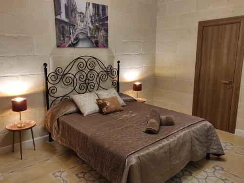 a bedroom with a large bed with two lamps on it at Charming Town House Suite - Close to Airport in Paola