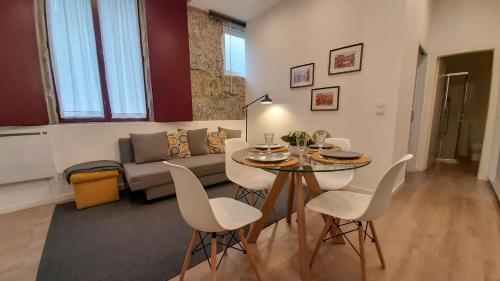 a living room with a table and a couch at Molarinho Heritage in Guimarães