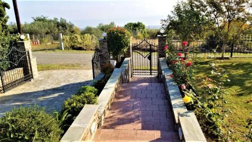 a garden with a gate and flowers at Apartment Achilles in Litochoro