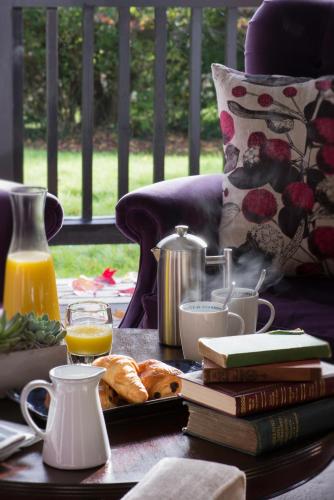 a table with books and orange juice and a plate of food at Burley Manor in Burley