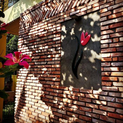 a brick wall with a window with a heart on it at Pink Tulip Hoi An in Hoi An