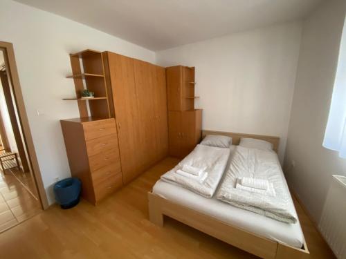 una piccola camera con letto e armadio in legno di iHome Apartment 3.0 a Pécs