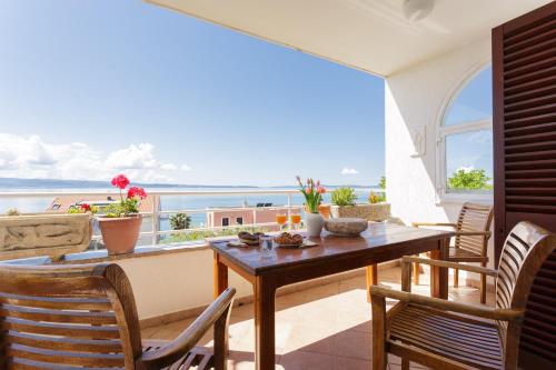 uma varanda com mesa e cadeiras e vista para o oceano em Apartments Sunrise em Split