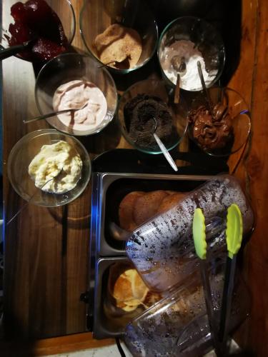 a table topped with plates of pastries and ice cream at Chata pod Studničnou in Pec pod Sněžkou