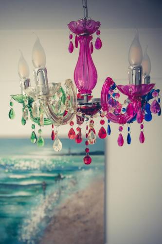 a chandelier with two pink vases and beads on it at Seafront Luxury residence with amazing view in Vasiliki