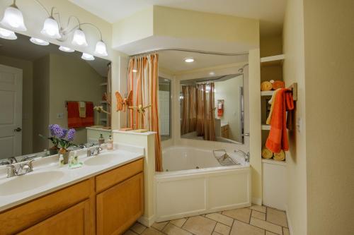 a bathroom with a tub and a sink and a mirror at Holiday Inn Club Vacations Holiday Hills Resort at Branson in Branson