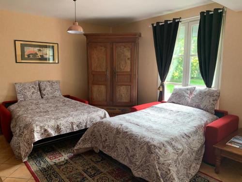 a bedroom with two beds and a window at Villa Toulousaine in Grisolles