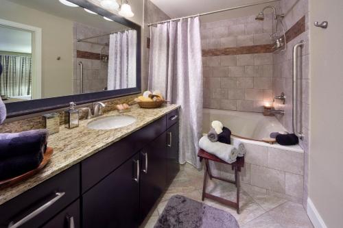 a bathroom with a sink and a tub and a mirror at Holiday Inn Club Vacations at Desert Club Resort in Las Vegas