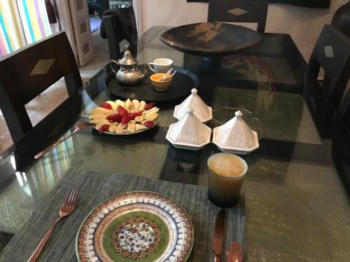 a glass table with a plate of food on it at Villa #1 ‘Rosalie’ in Marrakech