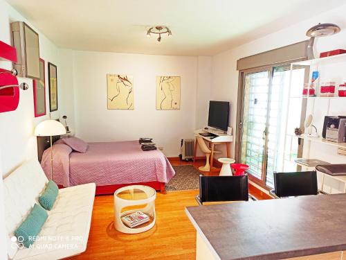 Cette chambre comprend un lit et un bureau avec une table. dans l'établissement Armengual Centro, à Malaga