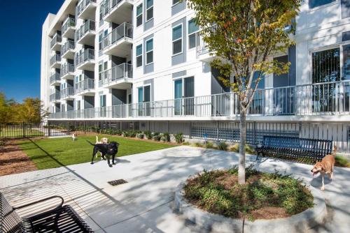 a man sitting on a bench in front of a building at Spectacular Apartments by BCA Furnished Apartments in Atlanta