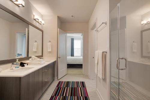 a bathroom with a sink and a mirror and a shower at Spectacular Suites by BCA Furnished Apartments in Atlanta