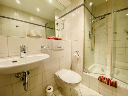 ein Bad mit einem WC, einem Waschbecken und einer Dusche in der Unterkunft Villa Seepark - Ferienwohnung 9 in Heringsdorf