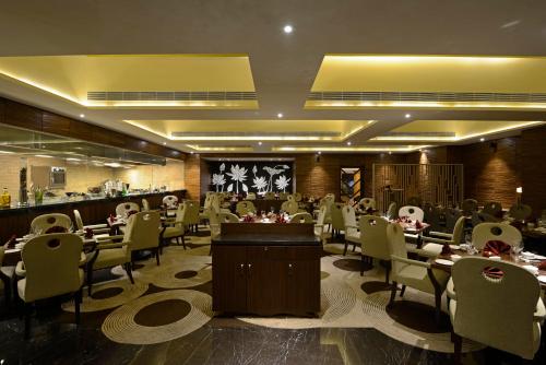 a restaurant with tables and chairs and a bar at Sun-n-Sand Mumbai Juhu Beach in Mumbai