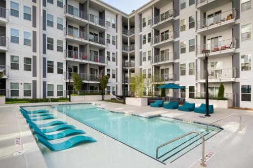 アトランタにあるSpectacular Suites by BCA Furnished Apartmentsのアパートメントの建物の前にスイミングプールがあります。