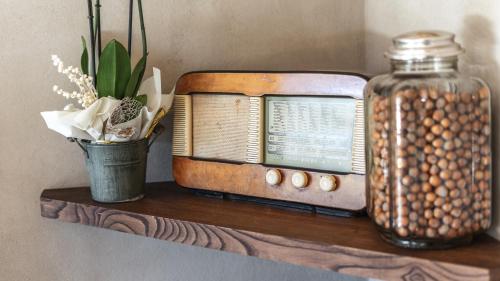 an old radio sitting on a shelf with a jar at Agriresort Villa Gelso- Adults Friendly in Vesime