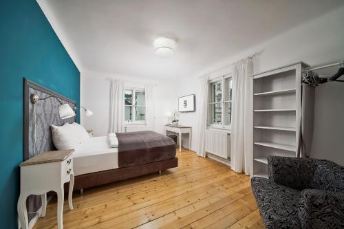 1 dormitorio con cama, escritorio y silla en Salzburg Residence by Welcome to Salzburg en Salzburgo