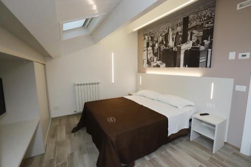 a bedroom with a bed and a painting on the wall at Orchidea Rooms & Suites in Civitanova Marche