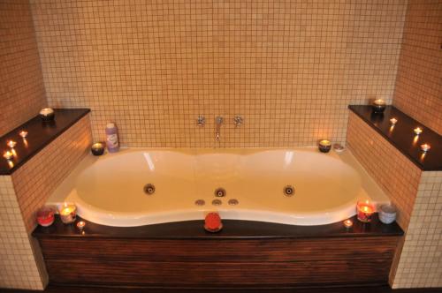 un bagno con grande vasca da bagno con candele di Hotel Nord a Ploieşti