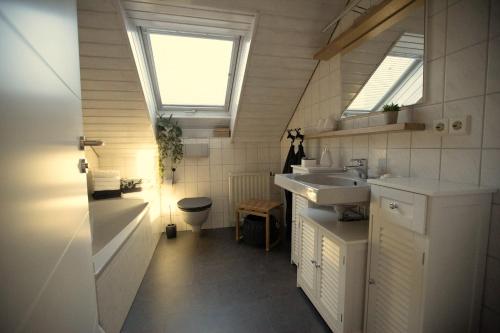 a bathroom with two sinks and two windows at Ferienapartment Finke in Welzheim