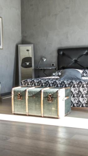 a bedroom with a bed and a trunk on the floor at Agriresort Villa Gelso- Adults Friendly in Vesime