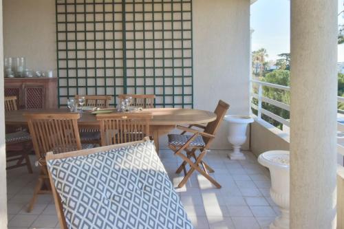un patio avec une table et des chaises sur un balcon dans l'établissement 3-Br Apartment Sea View Swimming Pool, à Cannes