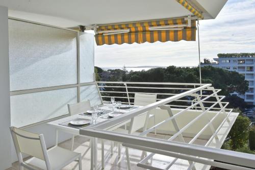 un tavolo bianco e sedie sul balcone di Cannes Hillside With terrace and swimming pool a Cannes