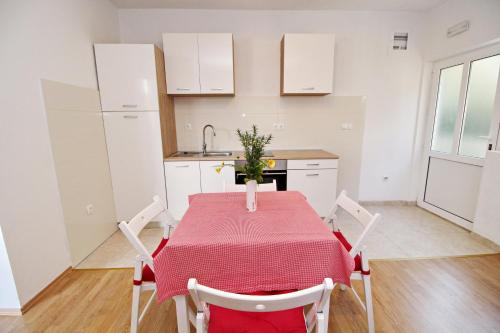 a kitchen with a table with a red table cloth at Apartments Nodilo in Polače