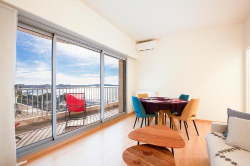 une salle à manger avec une table et des chaises et une grande fenêtre dans l'établissement Violet, bord de mer, à Cannes