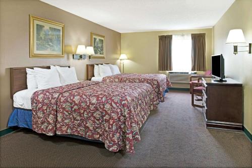 een hotelkamer met 2 bedden en een televisie bij Days Inn by Wyndham Collinsville St Louis in Collinsville