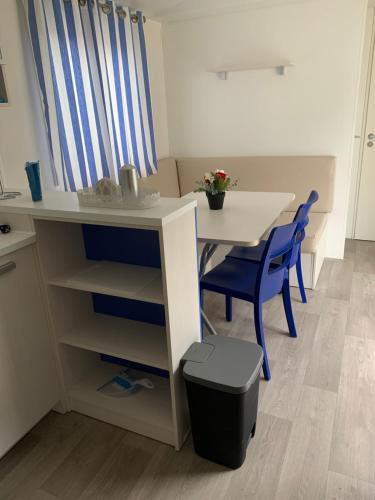 uma pequena cozinha com uma mesa e cadeiras azuis em Villa Granja Sol em São Félix da Marinha