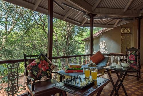 - une terrasse couverte avec un échiquier sur une table dans l'établissement SaffronStays Parsi Manor, Matheran, à Matheran