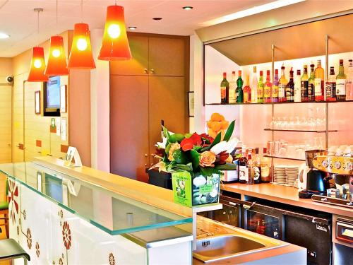 - une cuisine avec un comptoir orné d'un vase de fleurs dans l'établissement ibis Epinay sur Seine - Gennevilliers, à Épinay-sur-Seine